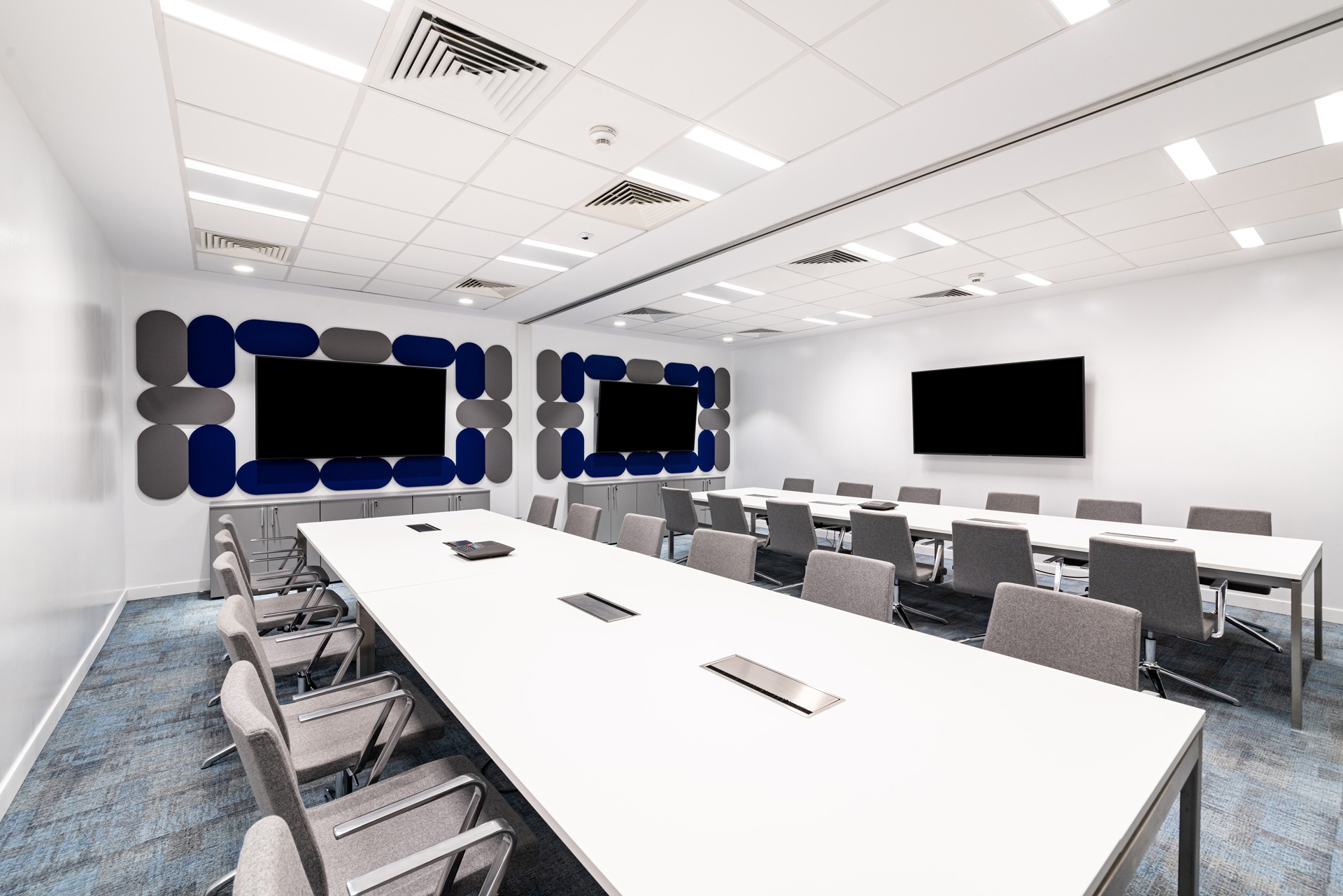 Perrigo Romania workplace project by STIRIXIS Group showing training room with presentation screen, dark acoustic ceiling and flexible seating layout