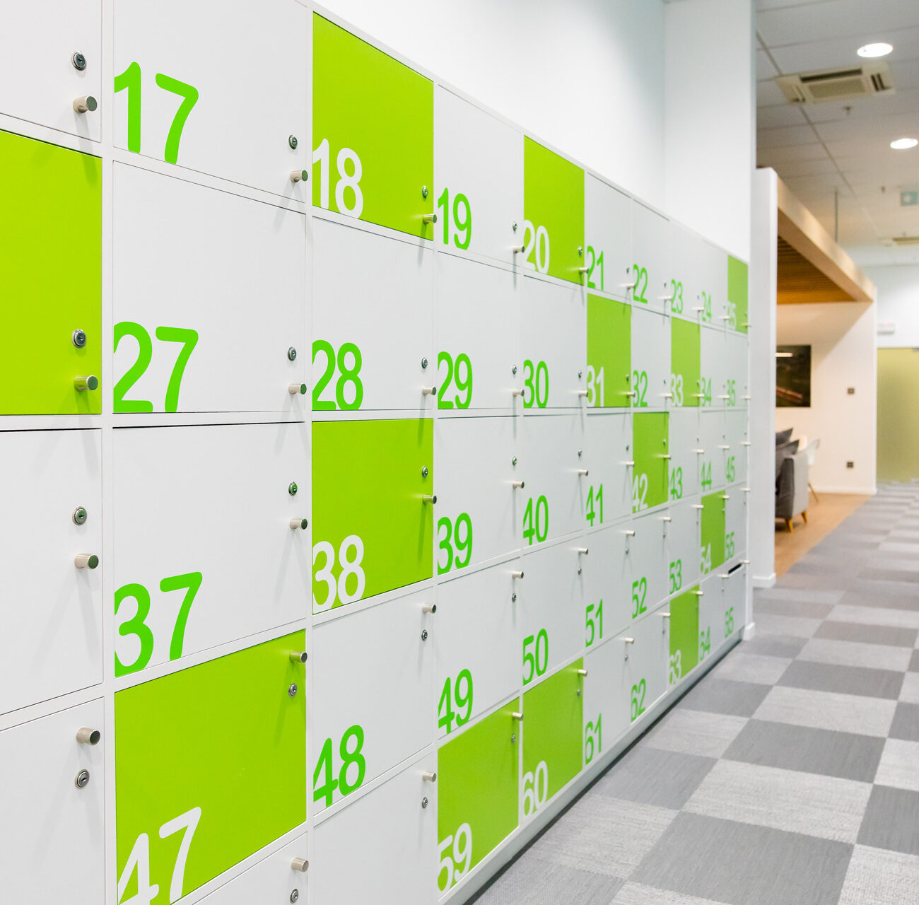 Schneider Electric headquarters workplace project by STIRIXIS Group showing corridor with green numbered locker wall and bold brand identity
