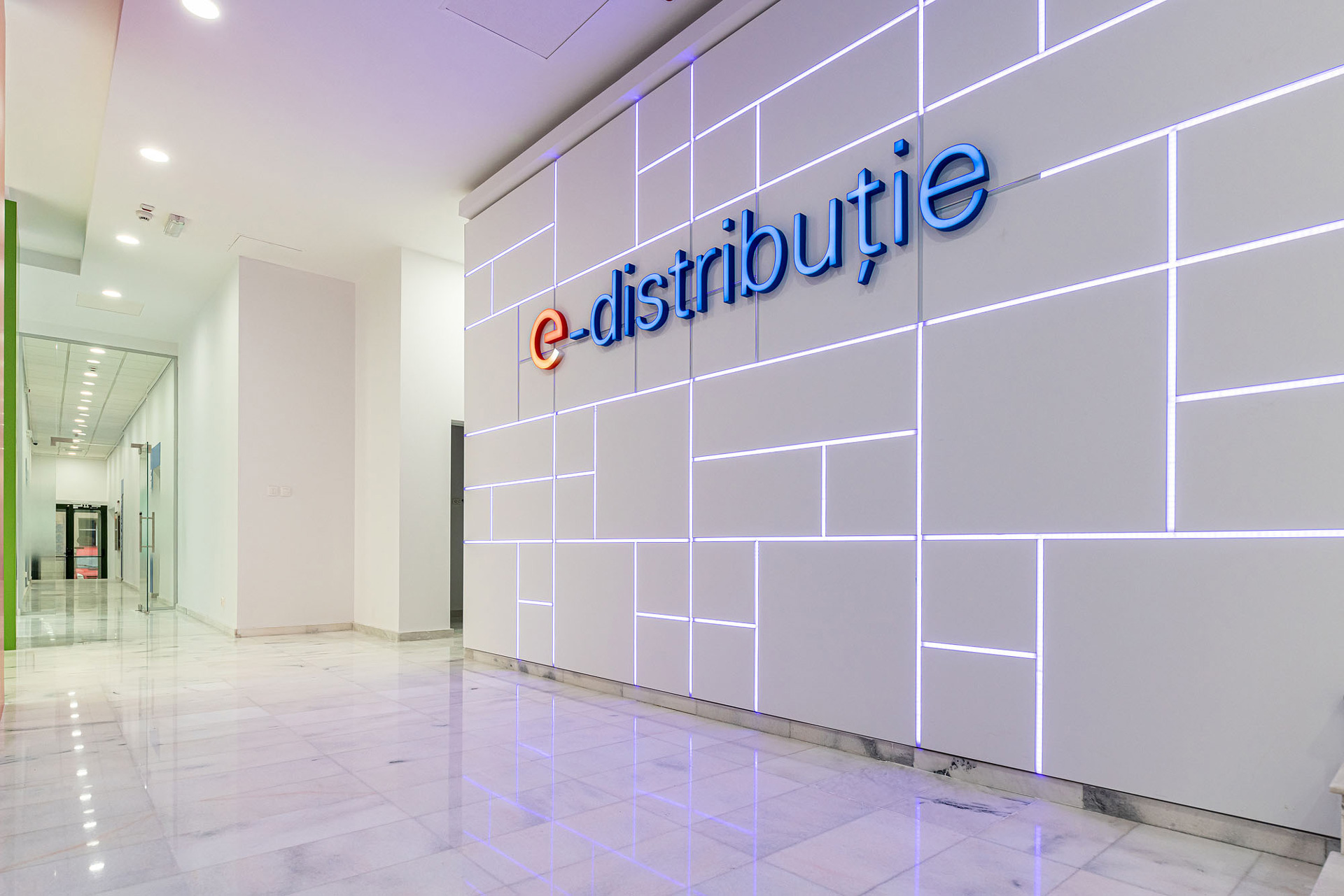 E-Distributie by Enel workplace project by STIRIXIS Group showing reception area with illuminated e-distributie logo wall and open entrance