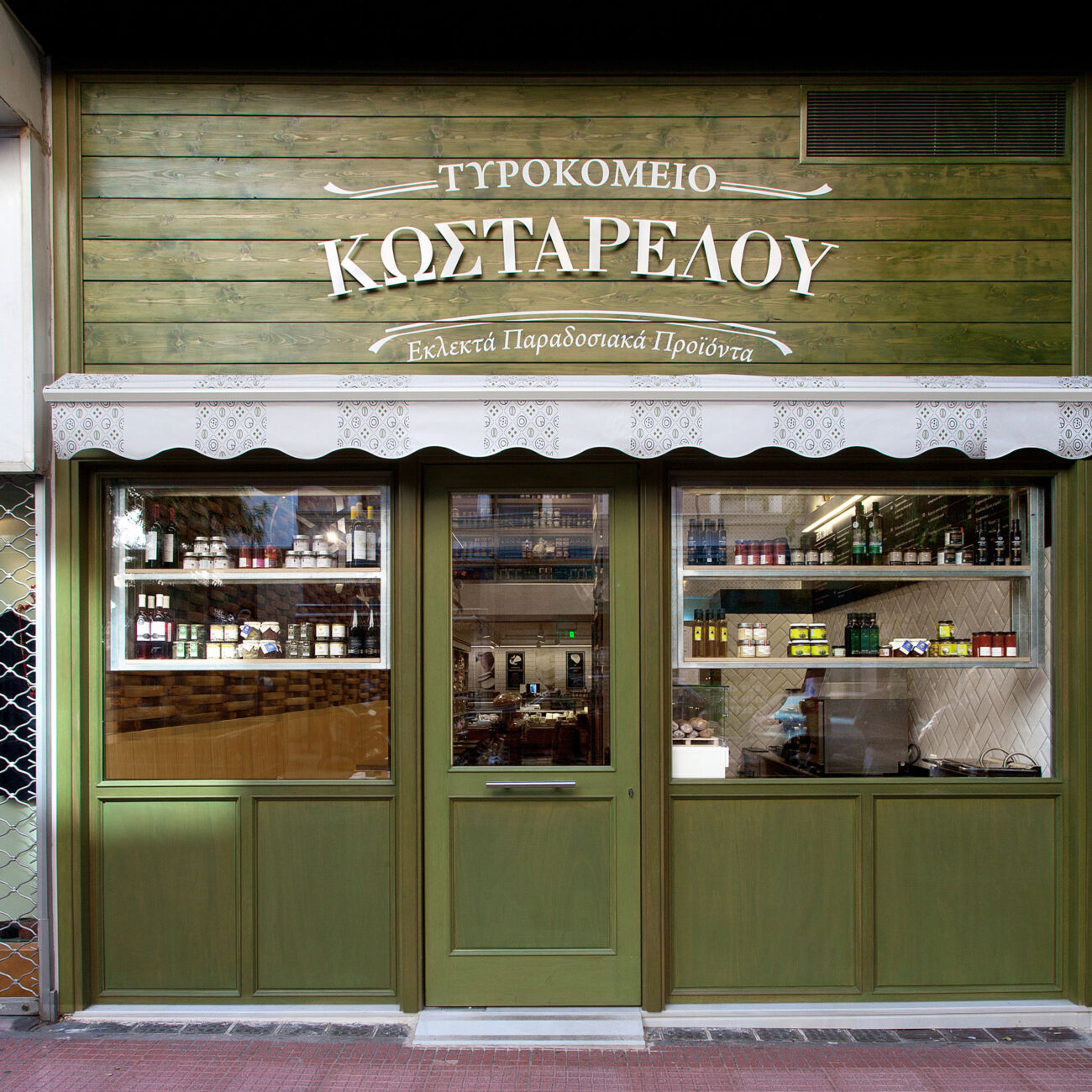 Kostarelos Deli hospitality project by STIRIXIS Group showing exterior facade with traditional Greek lettering signage and dark green shopfront