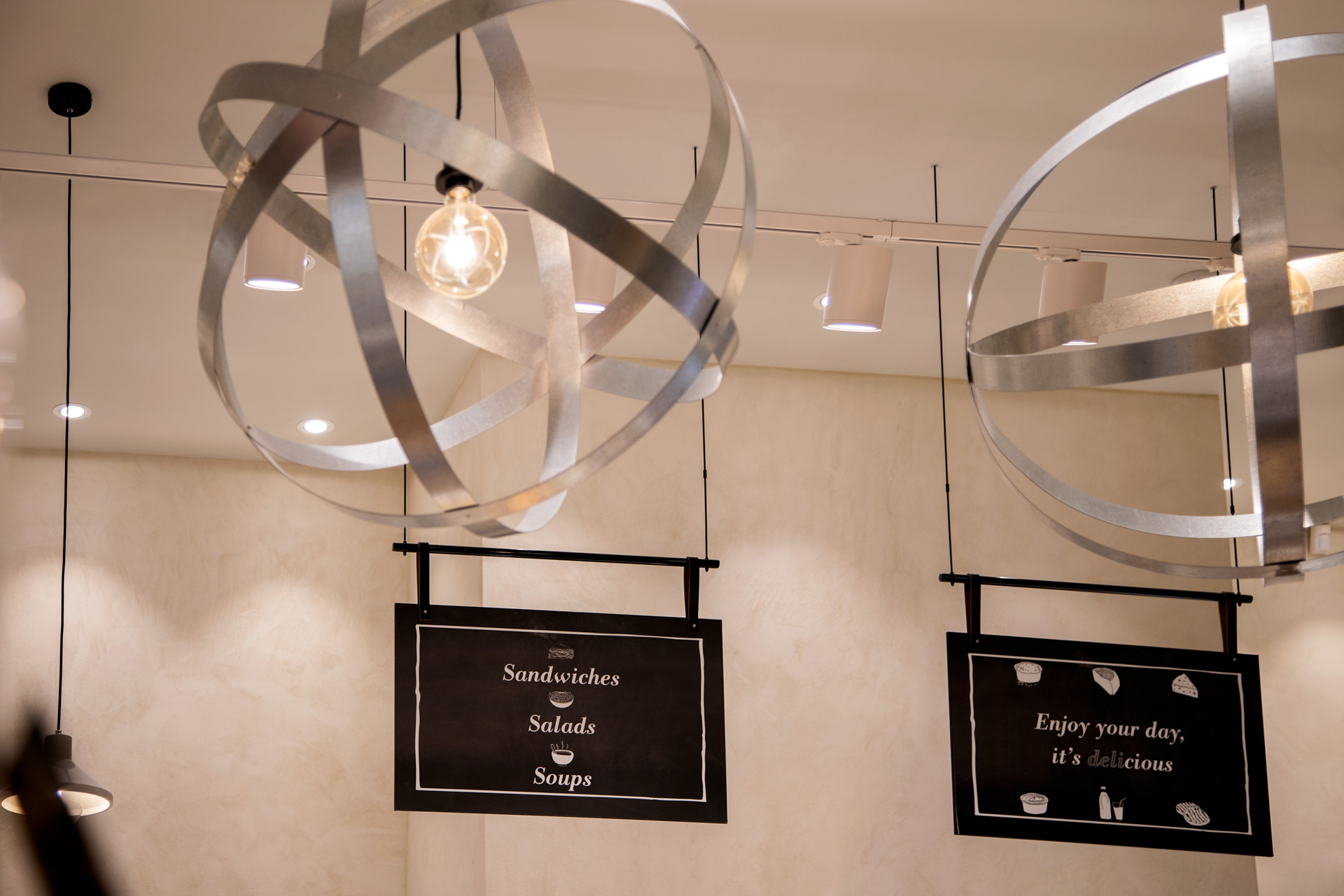 Kostarelos Greek Delicacies retail project by STIRIXIS Group showing statement sculptural lighting installation above product display area