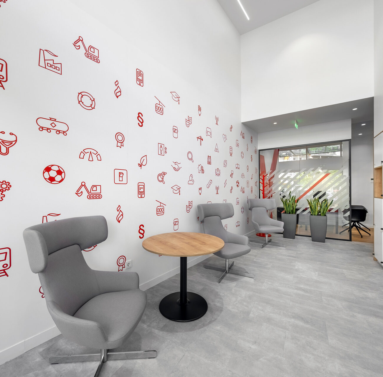 TUV Austria Hellas workplace project by STIRIXIS Group showing Thessaloniki lounge with playful illustrated brand wall and relaxed seating area
