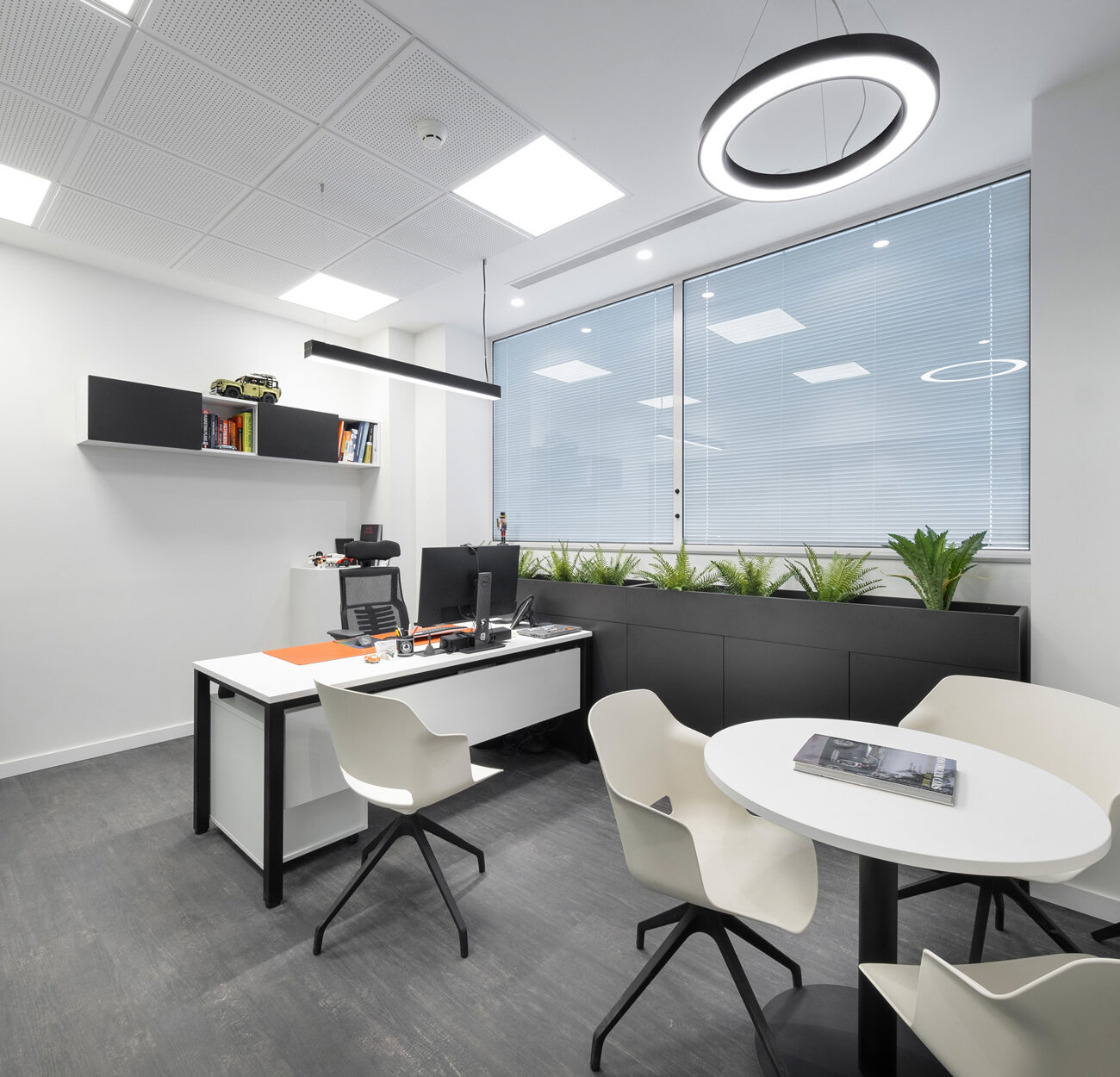 Petros Petropoulos workplace project by STIRIXIS Group showing private office with circular mirror detail and clean minimal desk layout