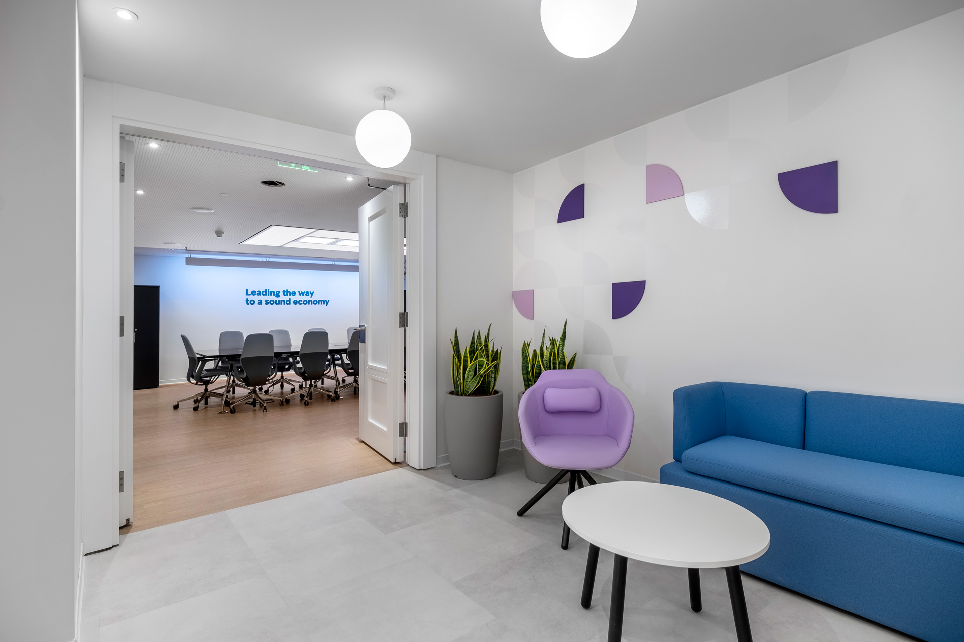 Intrum hybrid office workplace project by STIRIXIS Group showing breakout lounge with blue sofa and informal meeting area