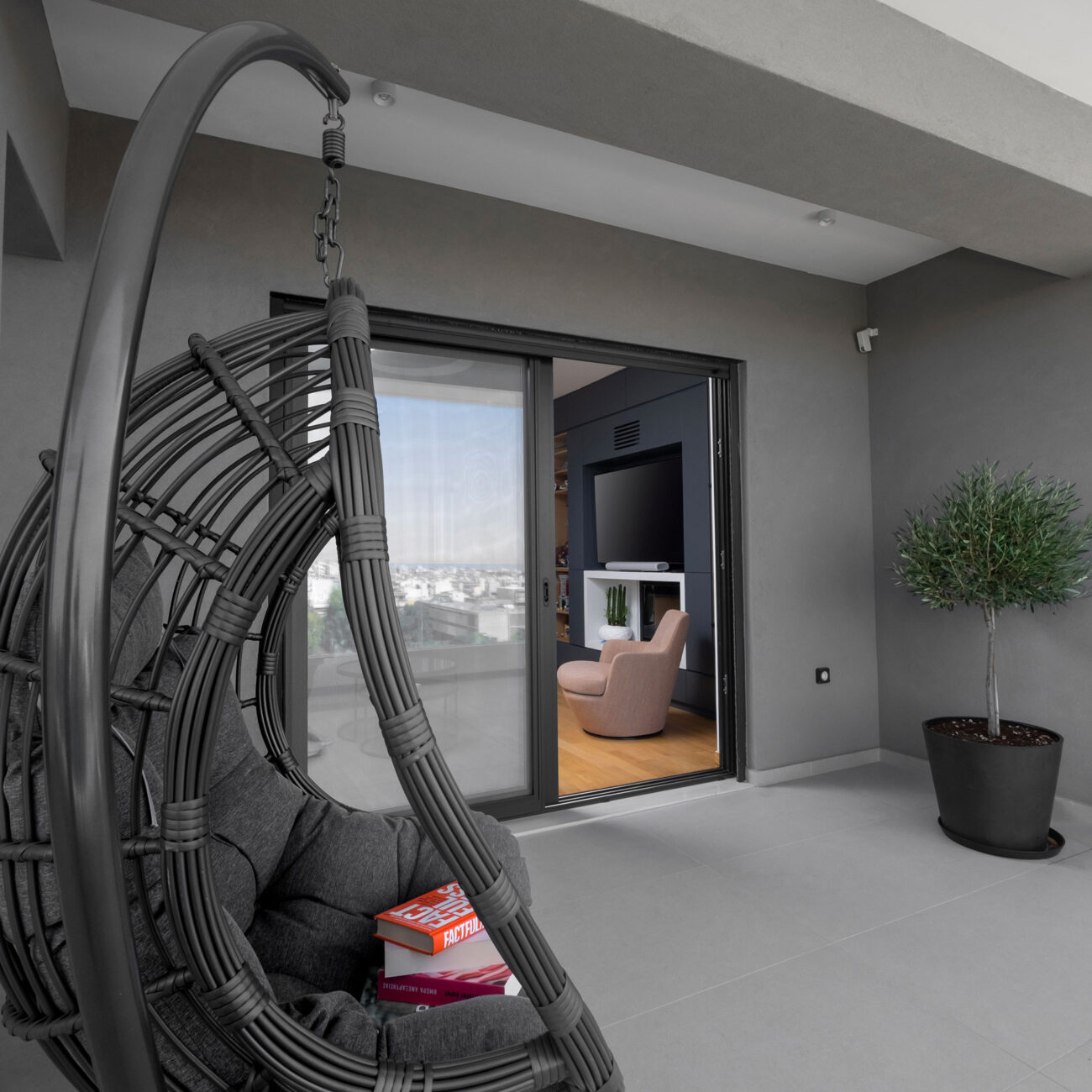 Contemporary Apartment by STIRIXIS Group showing balcony with hanging chair and urban outdoor space