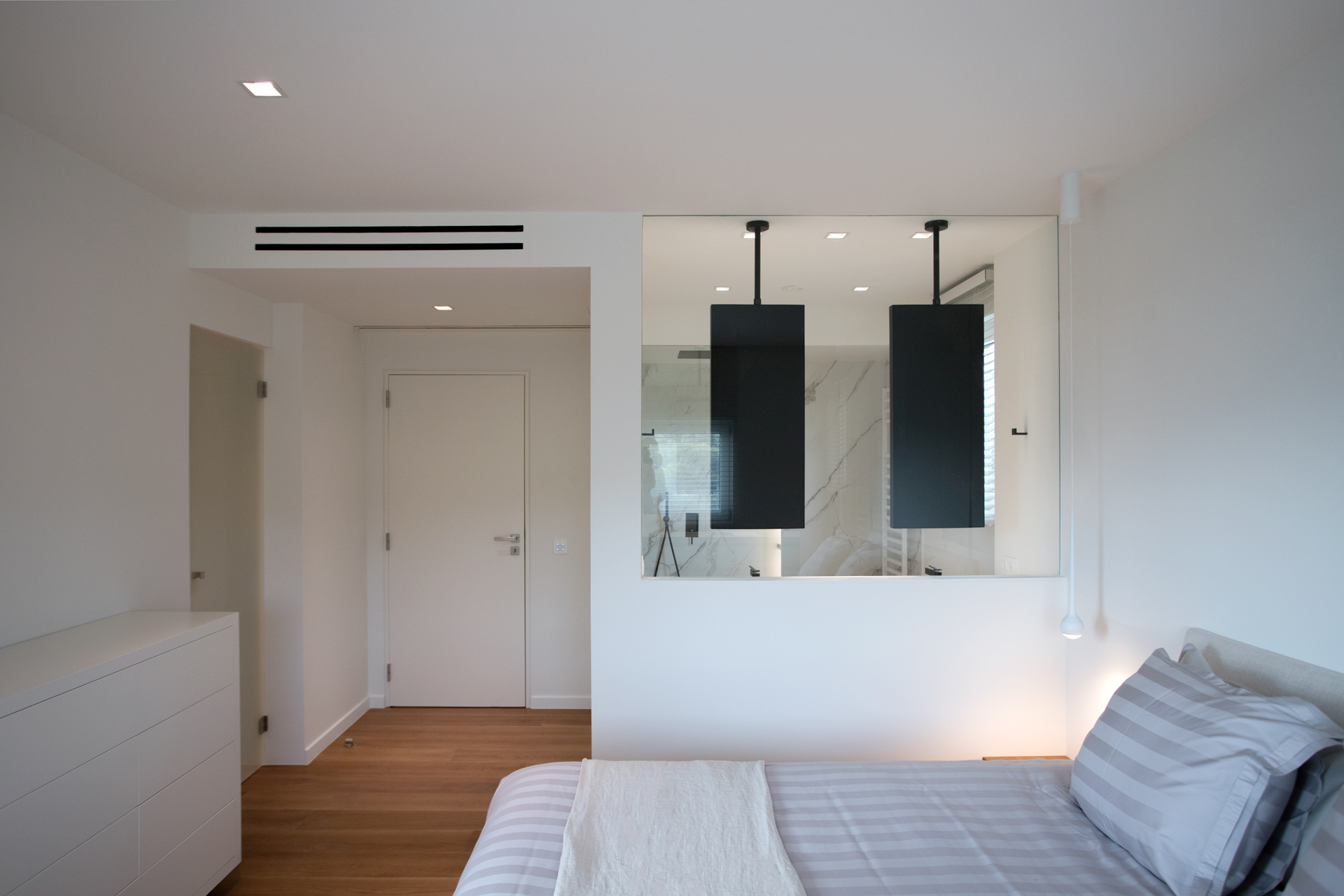 Pure Elegance residential project by STIRIXIS Group showing minimal bedroom with pendant lighting and clean white walls
