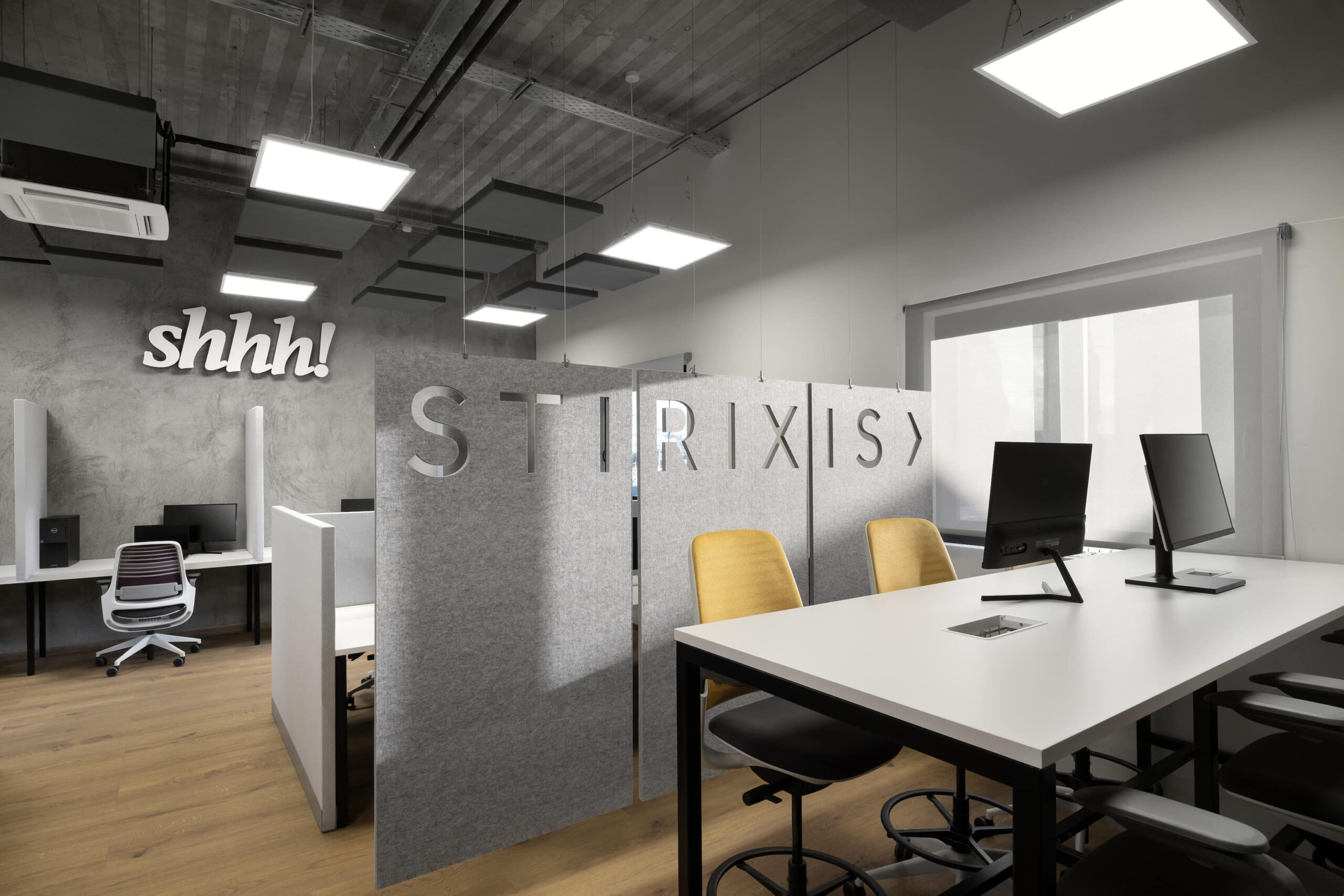 STIRIXIS Group Athens workplace project showing open office with STIRIXIS logo wall and clean white workstation layout