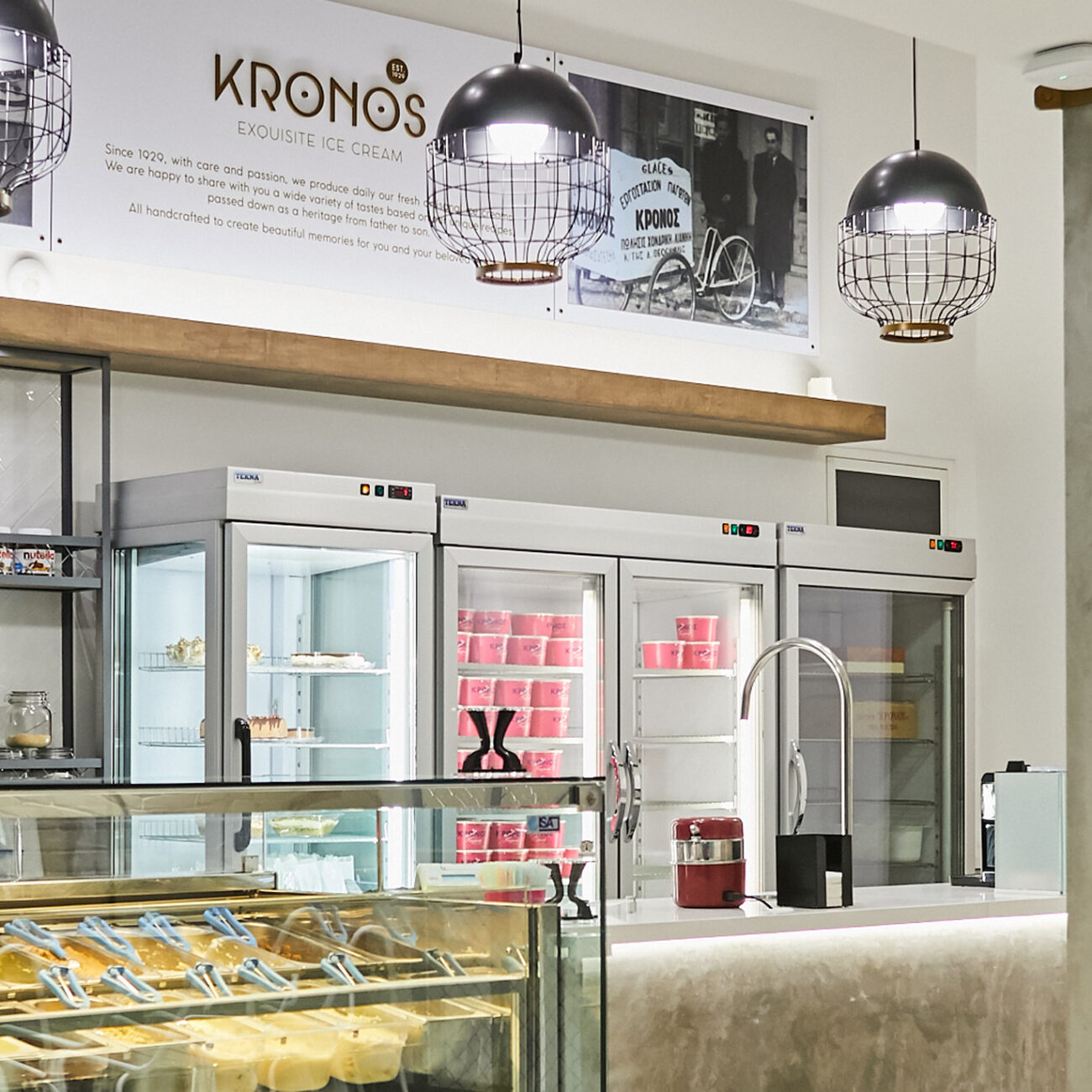 Kronos ice cream retail project by STIRIXIS Group showing product display counter with industrial pendant lighting and brand wall signage