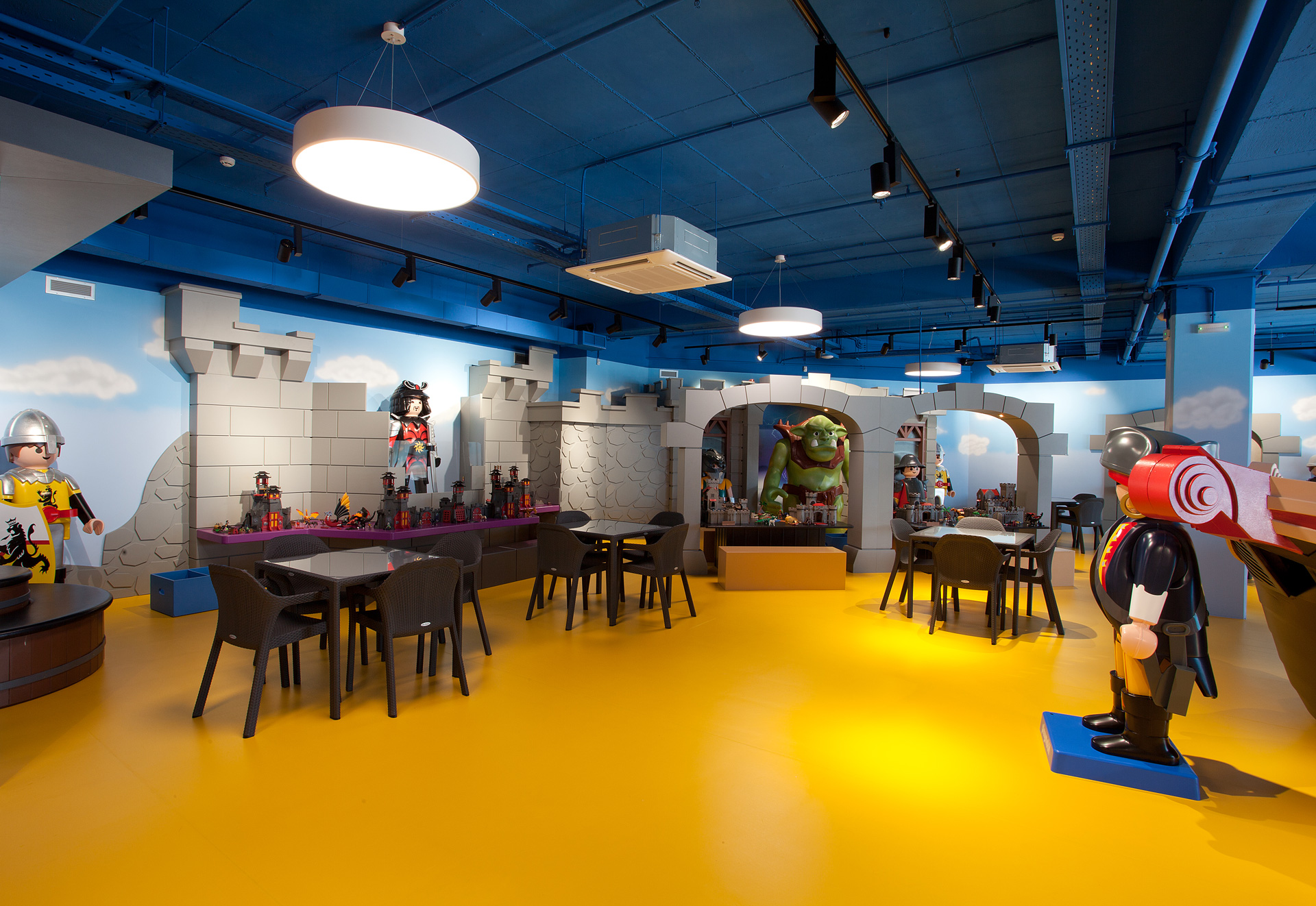 Playmobil Hellas retail project by STIRIXIS Group showing open FunPark play floor with yellow flooring and themed character displays