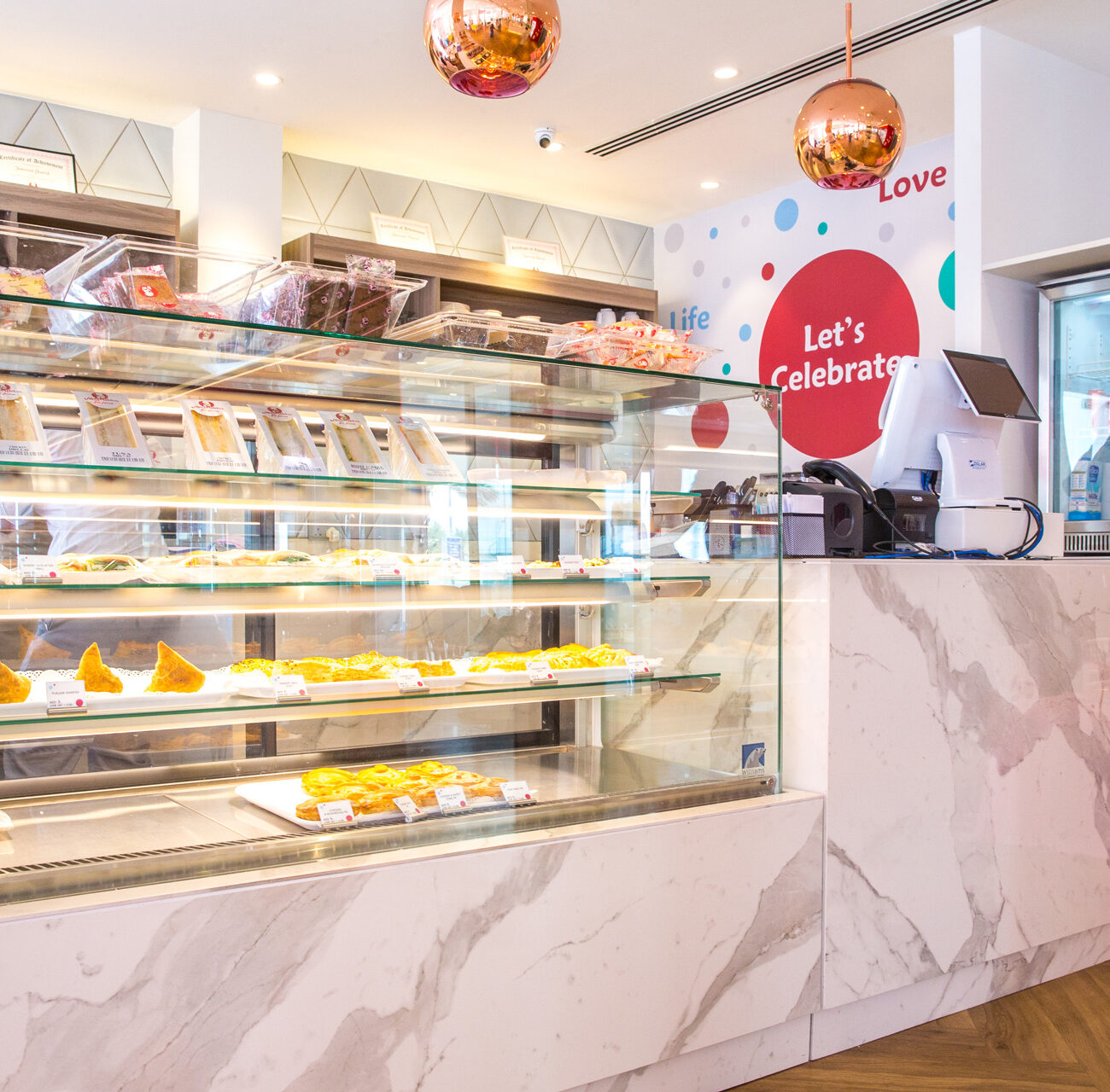 Mister Baker retail project by STIRIXIS Group showing marble service counter with fresh pastry display and customer service area