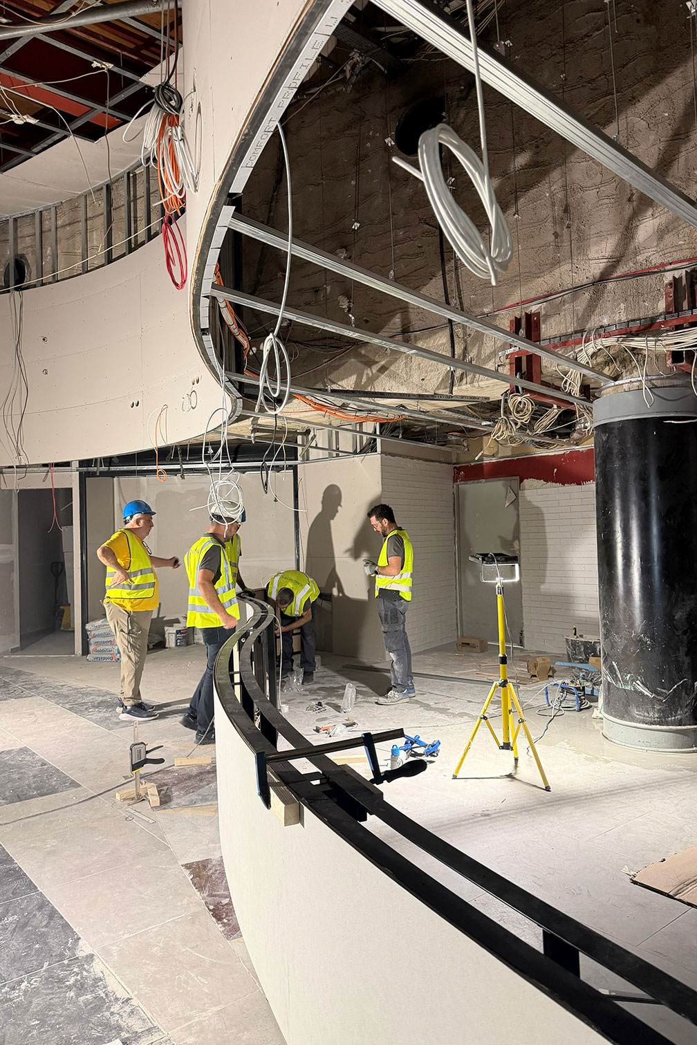 Construction team coordinating specialist works inside an entertainment venue during project delivery.